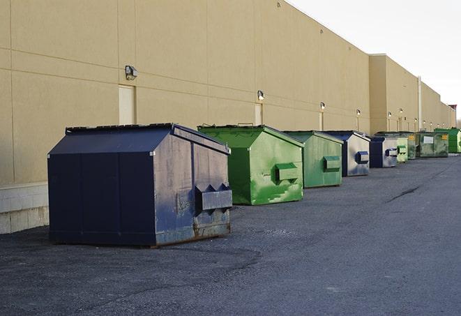 tilted front-load dumpsters being emptied by waste management workers in Blaine